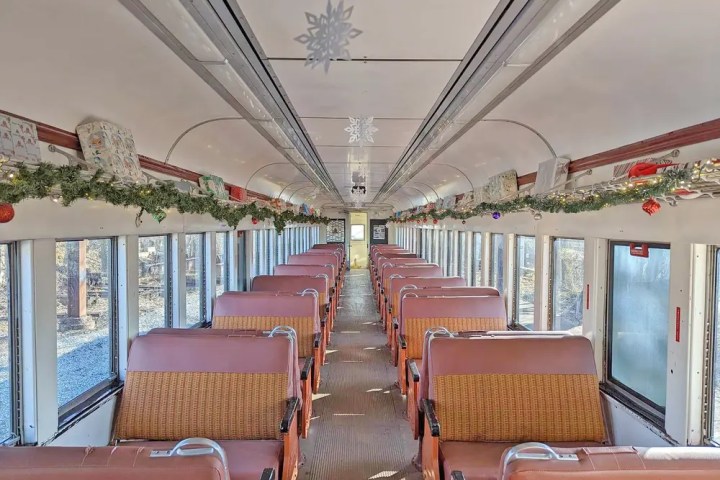 Decorated vintage train interior with festive garlands and snowflakes.